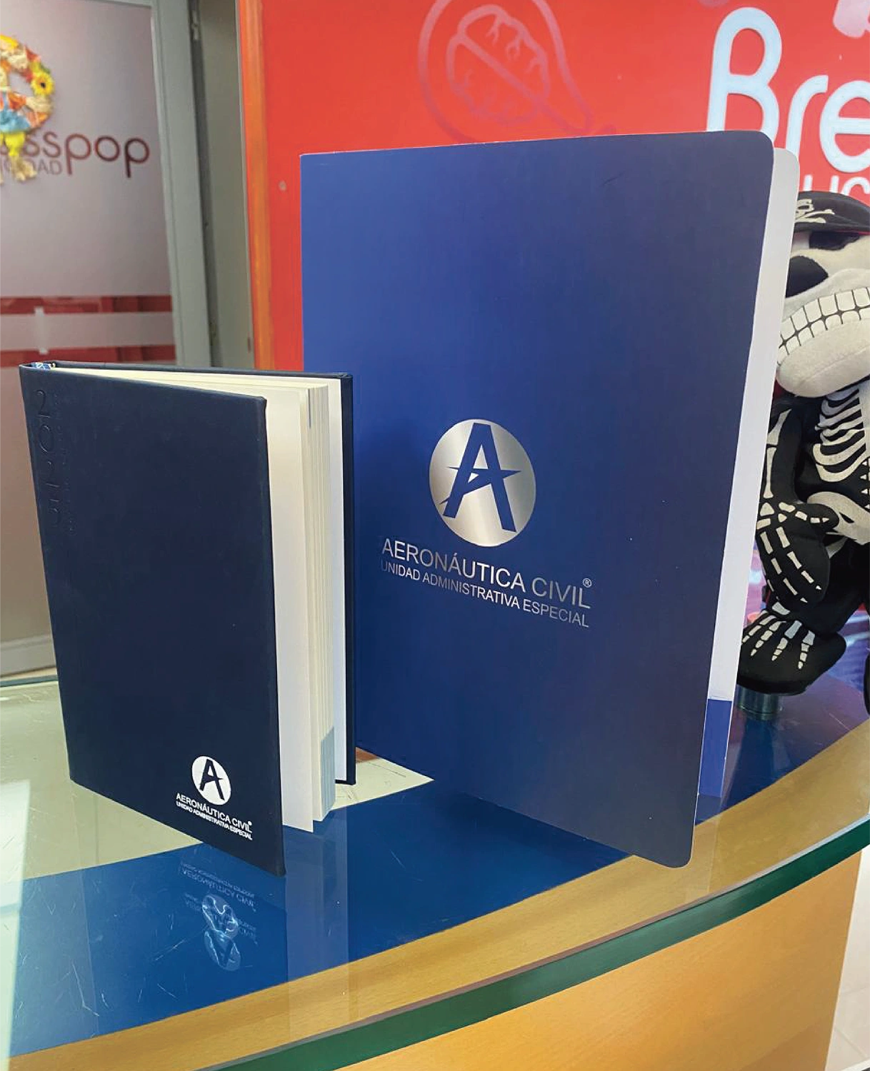 Kit de papelería corporativa premium de la Aeronáutica Civil: agenda de tapa dura y carpeta institucional con acabados litográficos de lujo, diseñados y producidos por Bresspop.