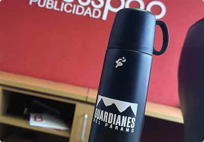 Termo metálico negro personalizado con logo de 'Guardianes del Páramo' impreso por Bresspop, ideal para material POP y merchandising empresarial de alta calidad.