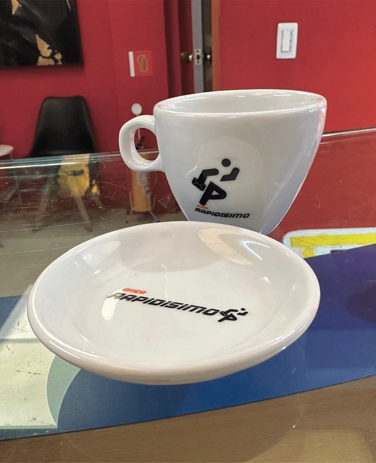 Juego de pocillo y plato de cerámica blanca personalizados con el logo de Inter Rapidísimo, fabricados por Bresspop para merchandising y regalos corporativos.